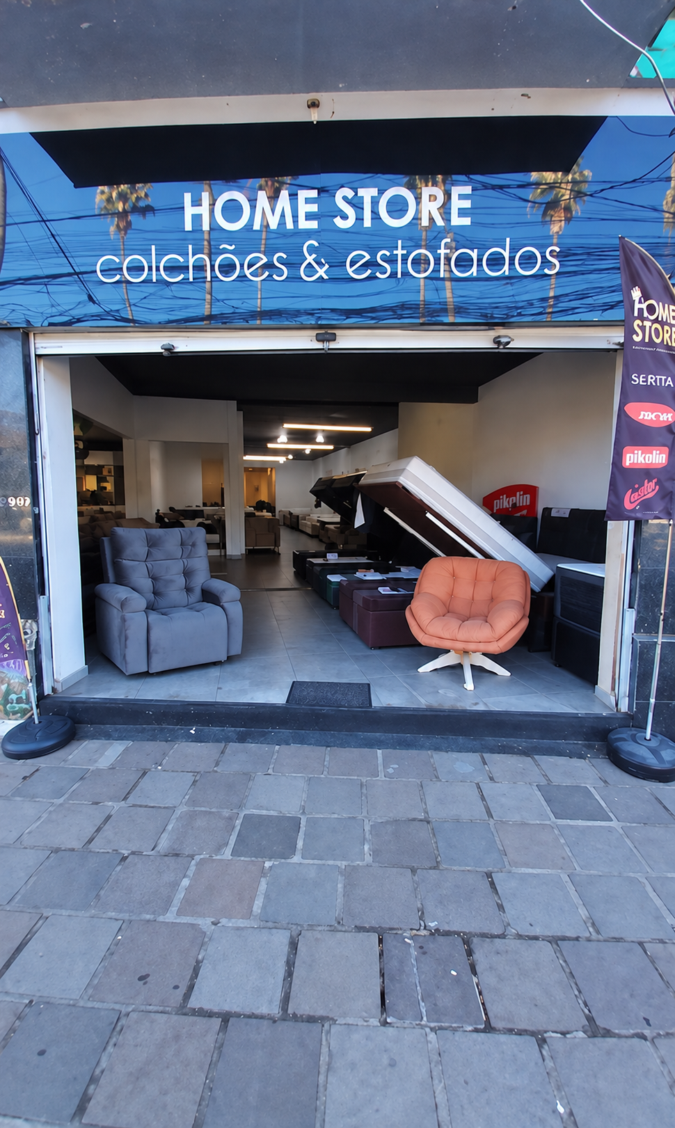 Fachada da Home Store, com a placa da loja e os estofados na entrada